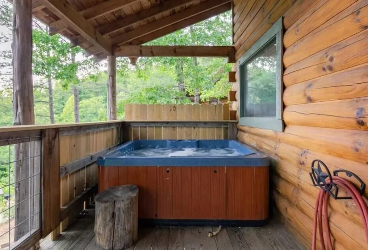 A tranquil outdoor scene featuring a bubbling hot tub set on a wooden deck, surrounded by lush trees. The deck provides a cozy, private atmosphere perfect for soaking under the stars or enjoying a morning coffee amidst nature.